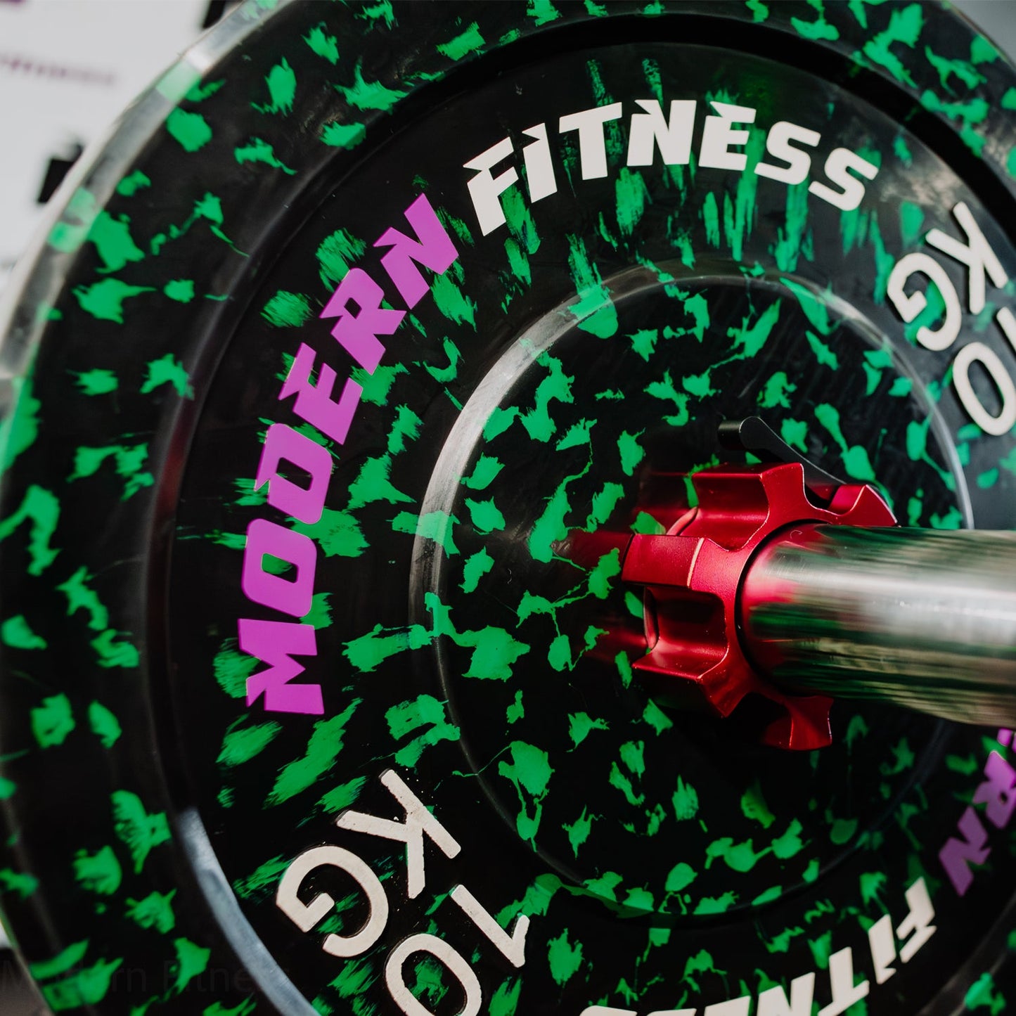modernfitness camouflage rubber Olympic weight plate in black and green with a red barbell collar