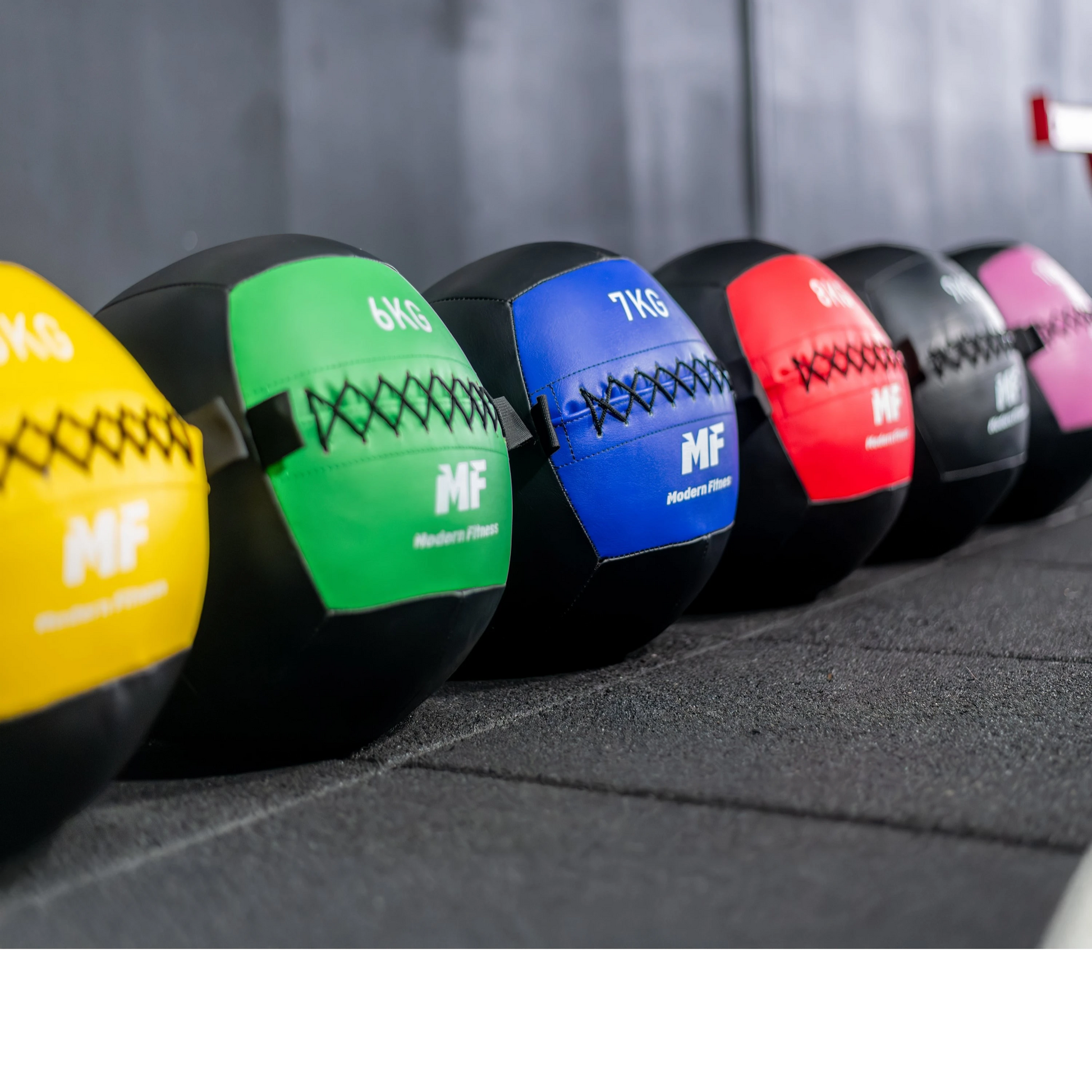modernfitness color-coded wall balls in a row, featuring durable textured PU construction for functional fitness.